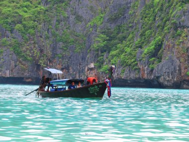 Phuket, Phuket Tayland - 10 15 2012: Taylandlı erkekler tarafından işletilen ahşap tekne güzel pitoresk sahil boyunca yabancı turistlerin bir çift ile yelken