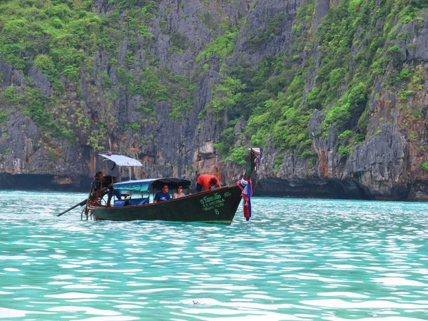 Phuket, Phuket Thailandia - 10 15 2012: barca di legno gestita da uomini thailandesi sta navigando con una coppia di turisti stranieri lungo la bellissima costa pittoresca — Foto Stock