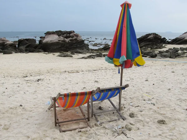 Couple of sun loungers and a folded beach tent stand on the shore of a deserted beach — Stock Photo, Image