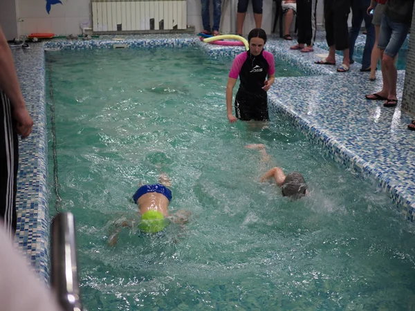 Rusya, Saratov - 12 Mayıs 2019: Çocuklar, sporcular, yüzücüler yüzmek için spor havuzunda pistler boyunca yüzüyor. Havuzda spor yüzme. çocuk spor — Stok fotoğraf