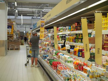 Süpermarketteki raftan choise yapan adam. Tüketicilik kavramı. Rusya, Saratov - 28 Nisan 2019