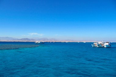 Kayalık kayalıkların arka planda sürüklenen tekneler ile Bay çok güzel görünümü.