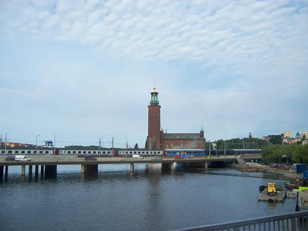 Stockholm, Suécia - Julho de 2007: paisagem urbana com vista para a Câmara Municipal, o rio e a ponte em que o comboio e os carros — Fotografia de Stock