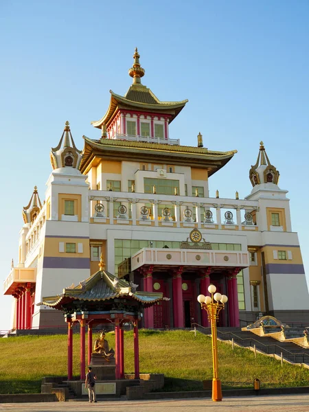 Touriste masculin se tient près de la statue de Bouddha à côté d'un beau temple bouddhiste — Photo