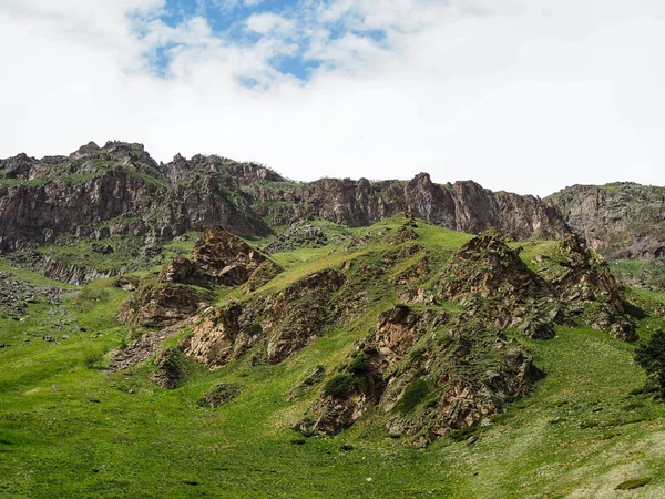 Bela paisagem com vista para as montanhas rochosas e montanhas cobertas com grama verde e arbustos — Fotografia de Stock