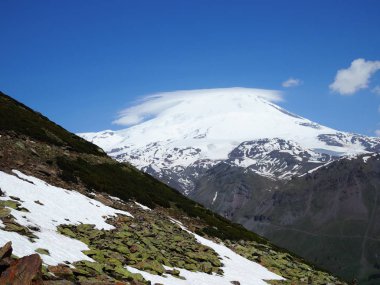 Büyük doğa sıradağları. Beyaz kar dağı veya yeşil alanlar, mavi gökyüzü arka plan ile volkan Elbrus amazing perspektif. Elbrus manzara görünümü - Rusya ve Avrupa'nın en yüksek zirvesi