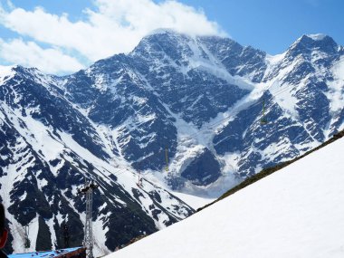 Yüksek karlı Kafkas dağları ve yedi rakamı şeklinde bir buzul. Dağların tepeleri Donguz Orun ve Nakra Tau. Elbrus region, Cheget.