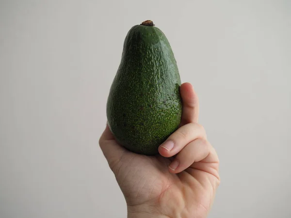 Green ripe avocado in human hand close-up — Stock Photo, Image