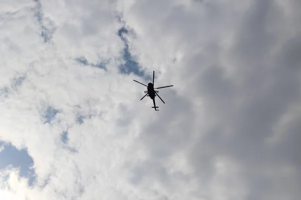 Large military helicopter hovers in sky. A camouflaged helicopter flies at high speed. — Stock Photo, Image