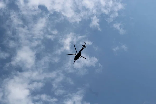 Nagy katonai helikopter lebeg az égen. Egy álcázott helikopter repül, nagy sebességgel. — Stock Fotó