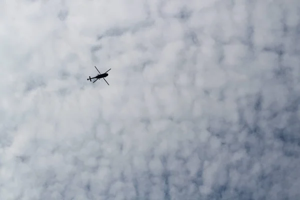 Nagy katonai helikopter lebeg az égen. Egy álcázott helikopter repül, nagy sebességgel. — Stock Fotó