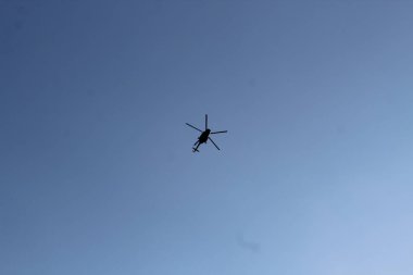 gökyüzünde büyük askeri helikopter hovers. Yüksek hızda kamufle bir helikopter uçar.