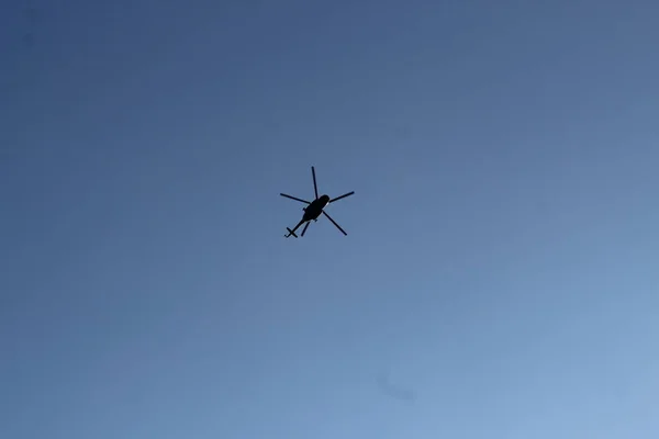 Ein großer Militärhubschrauber schwebt am Himmel. Ein getarnter Hubschrauber fliegt mit hoher Geschwindigkeit. — Stockfoto