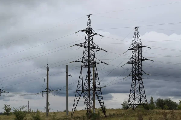 送電曇り空に対する高圧パワータワーの頂上. — ストック写真