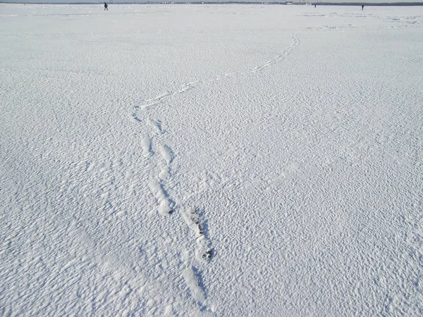 Lábnyomok a hóban megy el. a távolság körvonalazták az emberek. séta Baikal — Stock Fotó