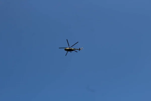 Militaire helikopter en een witte wolk in de blauwe hemel — Stockfoto