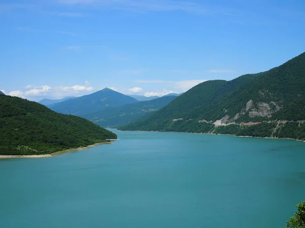 Красивий краєвид з видом на велике блакитне озеро в горах, покритих лісом — стокове фото