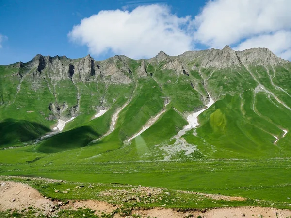 Bela paisagem com vista para as montanhas rochosas e montanhas cobertas com grama verde e arbustos . — Fotografia de Stock