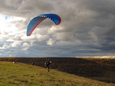 yamaç paraşütü sonbahar ormanına karşı atlamak için hazırlanıyor