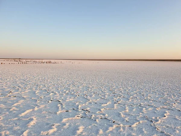 Vit yta av sjön täckt med salt vid soluppgången — Stockfoto