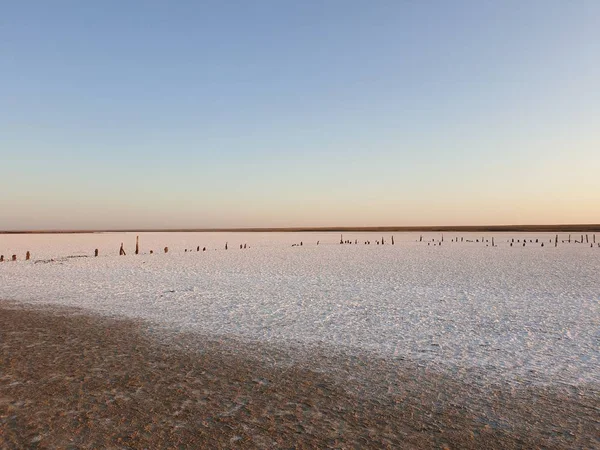 Vit yta av sjön täckt med salt vid soluppgången — Stockfoto