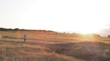 Adam gün batımında engebeli araziüzerinde çalışır. iz rekabet çalışan. Rusya, Saratov-Eylül 2019