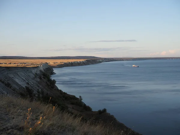 Belle rive escarpée de la rivière en automne avec vue sur la rivière sur laquelle flotte la péniche et un campement de tente sur le bord de la falaise . — Photo