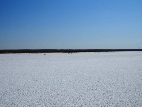 A napfelkeltekor sóval borított tó fehér felülete — Stock Fotó