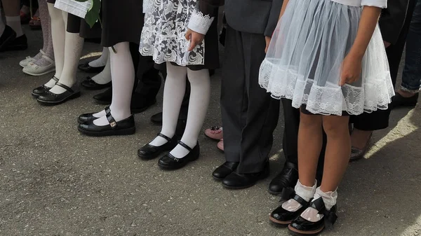 Børn indskrevet i første klasse med buketter af blomster i hænderne på skolen højtidelig parade - Stock-foto