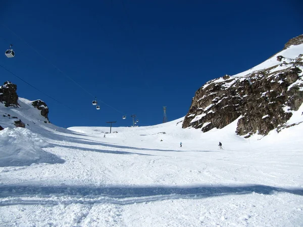アザウ渓谷、エルブラス山、ロシア連邦- 2010年2月:人々は山の斜面でスキーをしています. — ストック写真