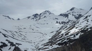 bulutlu havada karla kaplı dağın tepeleri.