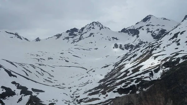 Cumbres de montaña cubiertas de nieve en clima nublado . — Foto de Stock