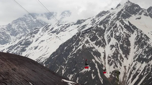 Teleférico rojo en el fondo de montañas cubiertas de nieve. fotografía aérea — Foto de Stock