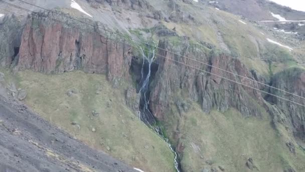 Güzel bir dağ şelalesinin havadan görünüşü. Dağlarda yaz manzarası. Kuzey Elbrus bölgesinin yeşil kayalık yamaçları. — Stok video