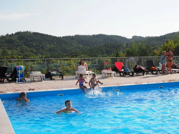 Gente Nada Las Piscinas Aire Libre Contra Telón Fondo Del —  Fotos de Stock