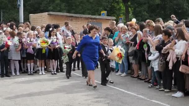 Ryssland, Saratov - 01 september 2019: förstaklassare med ballonger och flaggor går första lektionen i skolan den 1 september. — Stockvideo