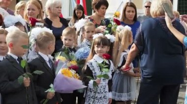 Rusya, Saratov - Eylül 2019: Okulun ilk günü. Lise öğrencileri birinci sınıfların önünde gösteri yapıyor. Okul bahçesinde üniformalı öğrenciler bekliyor..