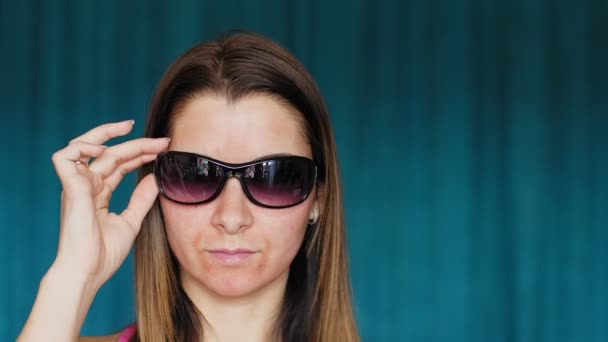 Flickan med hematom på ett ansikte. Fraktionerad laser. Följderna av kosmetologiförfarandet. Kvinnan tar av sig sina mörka glasögon som täcker blåmärke. — Stockvideo