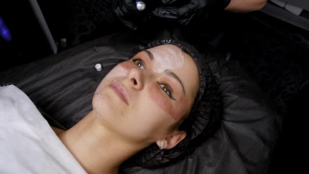 フラクショナル レーザー Co2。化粧品の手順です。手順の前に顔に鎮痛クリームを適用します。スキンケア クリニックのレーザー皮膚治療を持つ女性。4 k — ストック動画