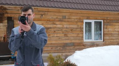 Termal görüntüleyici tarafından bir denetim yürüten evin işçi portresi. Isı kayıplarını aramak için. Isı kayıplarına karşı mücadele edin. Enerji tasarrufu.