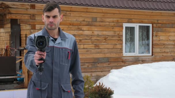 Ritratto del lavoratore della casa che sta effettuando un'ispezione da parte della termocamera. Per cercare perdite di calore. Lotta contro le perdite di calore. Risparmio energetico . — Video Stock