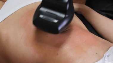 İnce kadın spa salonunda yatarken lpg aracı ile karnına vakum masajı yapıyor. Genç kadının güzel bir figür kozmetoloji prosedürü. 4k