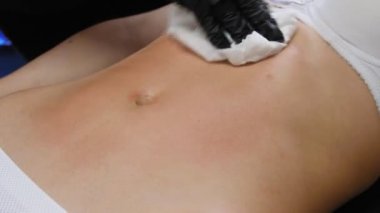 İnce kadın spa salonunda yatarken lpg aracı ile karnına vakum masajı yapıyor. Genç kadının güzel bir figür kozmetoloji prosedürü. 4k