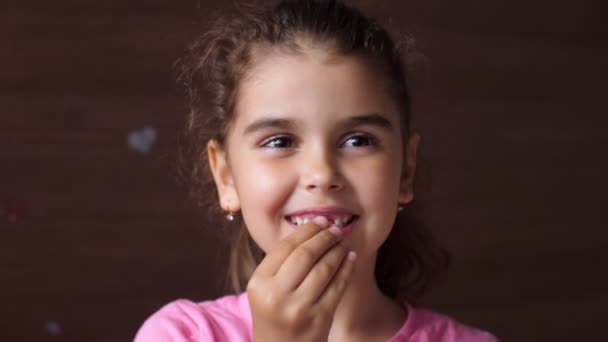 Retrato de una niña con una sonrisa sin dientes. Enmarca el diente roto donde estaba en la boca. Primeros dientes de leche perdidos . — Vídeos de Stock