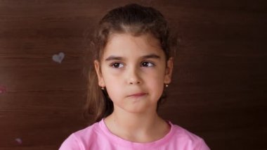 Kız çocuğu düşen dişin avucuna tükürür ve dişsiz bir gülümseme gösterir. İlk kaybedilen süt dişleri.