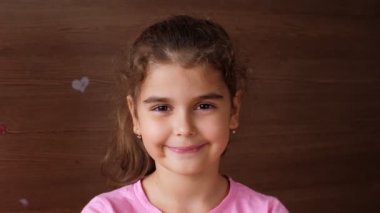 Kız çocuğu düşen dişin avucuna tükürür ve dişsiz bir gülümseme gösterir. İlk kaybedilen süt dişleri.