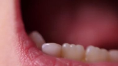 Bebek dişli makro atış. Dişsiz gülümseme. Titrek bir diş. Kök dişi kesiyorum. Dişlerinin arasındaki delikte bir dil.