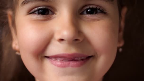 Ritratto di bambina con un sorriso sdentato. Il bambino ride forte. Non mostrare denti . — Video Stock