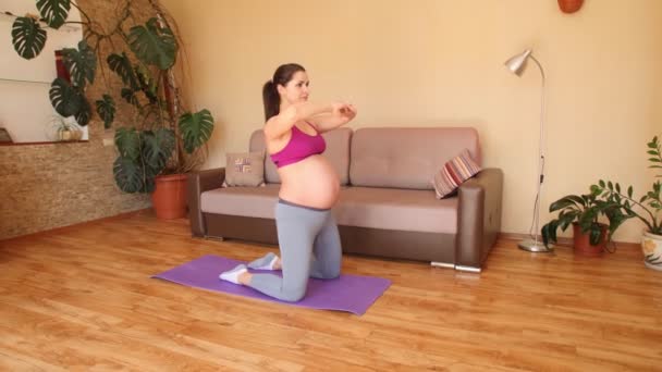 Молодая беременная женщина занимается фитнесом дома. Упражнения для беременных женщин. Приседания. Движение камеры. Steadicam — стоковое видео