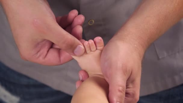 Masażysta robi masaż dziecku. Ręce masażystów ugniatają palce niemowląt. Masaż dla dzieci łagodzi ton. zbliżenie — Wideo stockowe